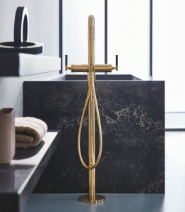 black ceaserstone bath with gold Grohe fittings in a luxurious bathroom