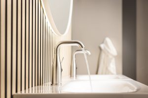Essence chrome tap from GROHE over stone vanity with slatted wooden wall