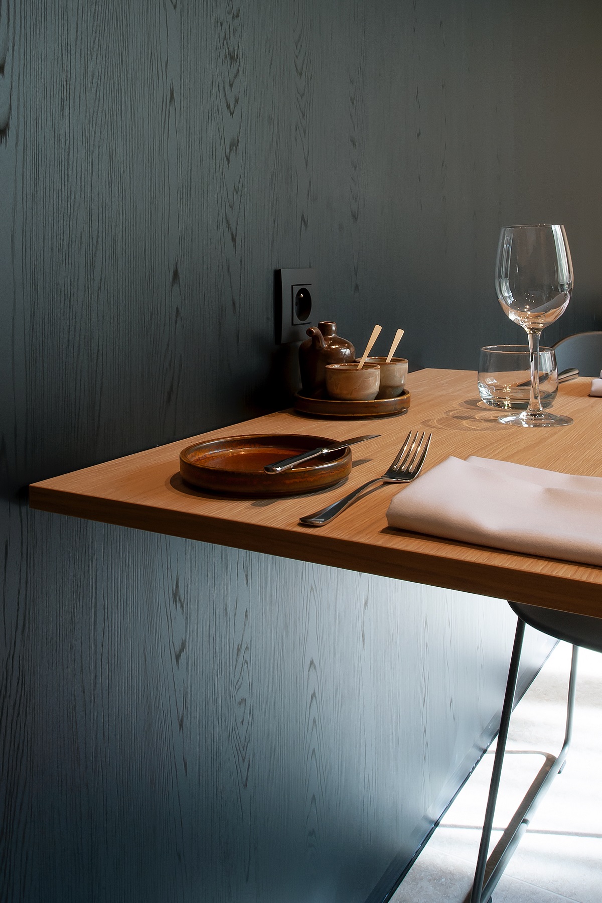restaurant table set against melamine printed wood surface panelled wall