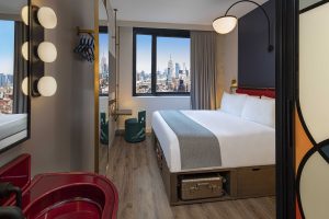 view from bathroom into guestroom with double bed and views across the city at Moxy Lower East side