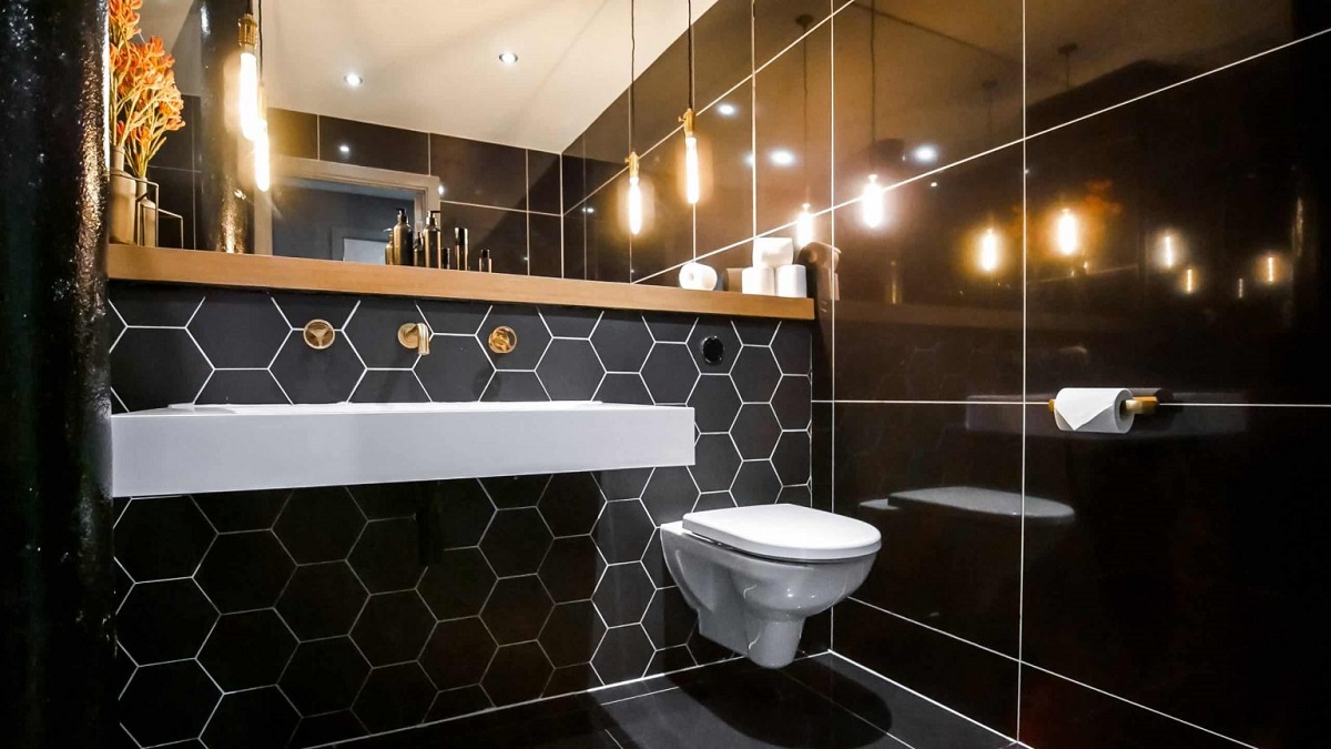black hexagon tiles contrast with large format black tiles and white lusso bathroom fittings