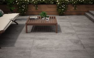 outdoor patio area with wooden furniture and large format grey outdoor tiles from RAK in Maremma Grey