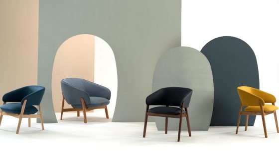 four wooden and upholstered chairs by Morgan against an abstract background in colour blocking