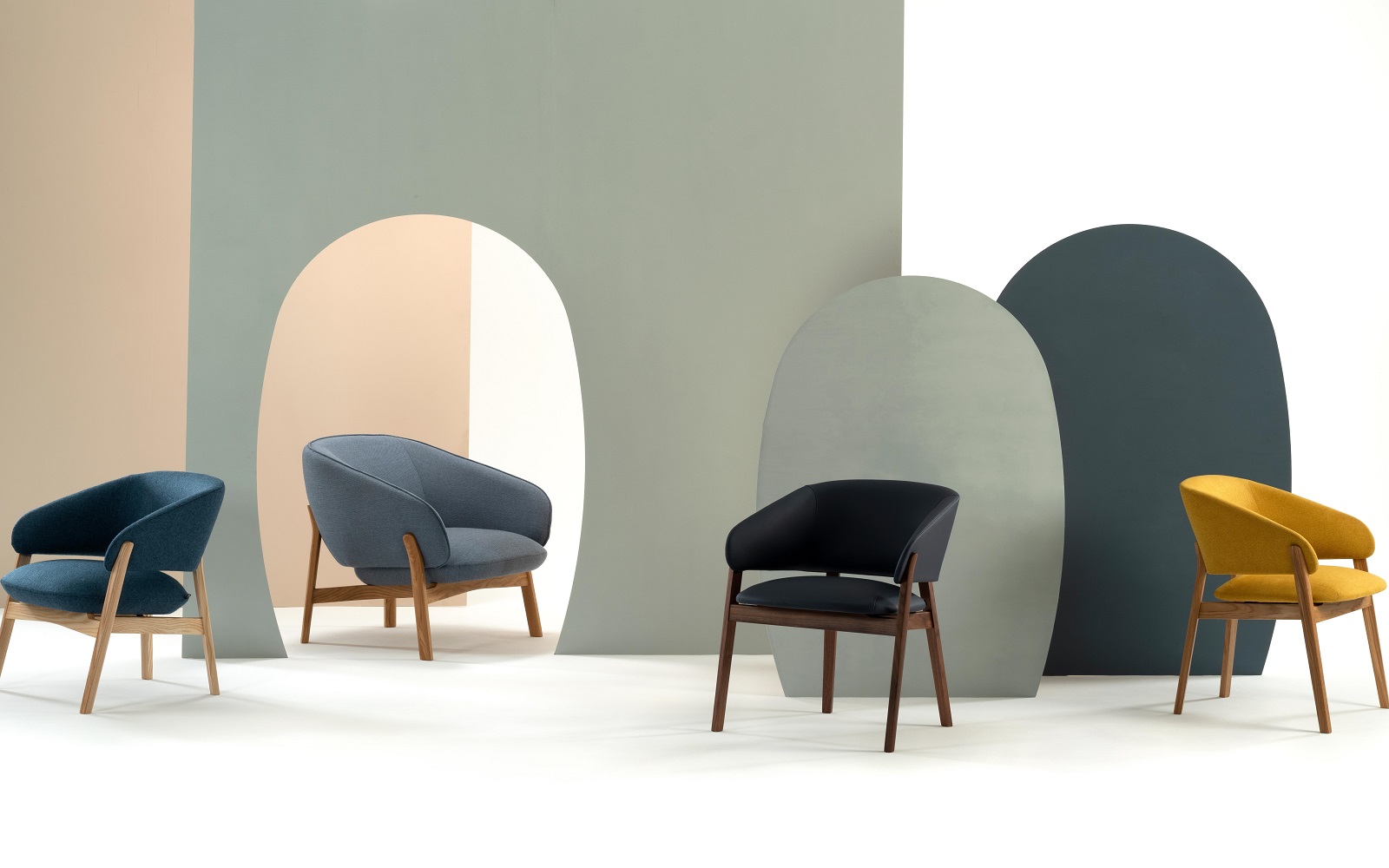 four wooden and upholstered chairs by Morgan against an abstract background in colour blocking