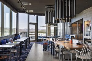 hotel public space with seating and bar running along floor to ceiling windows looking out over fjords and scenery in Tromso