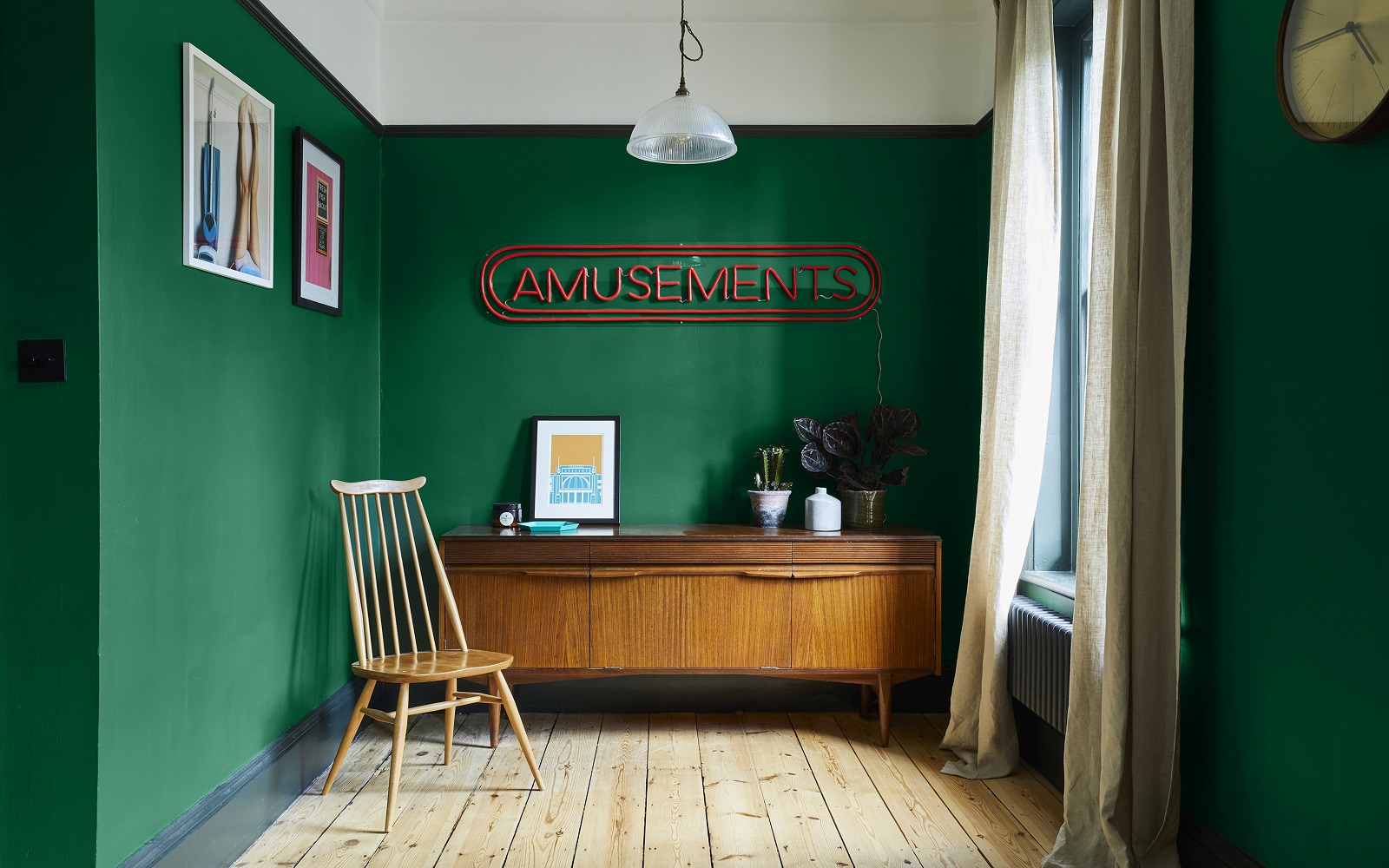 dark green walls and white ceiling in room with mid century chair and cabinet