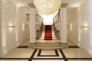 hotel lobby with graphic black and white marble flooring and red stairway carpet