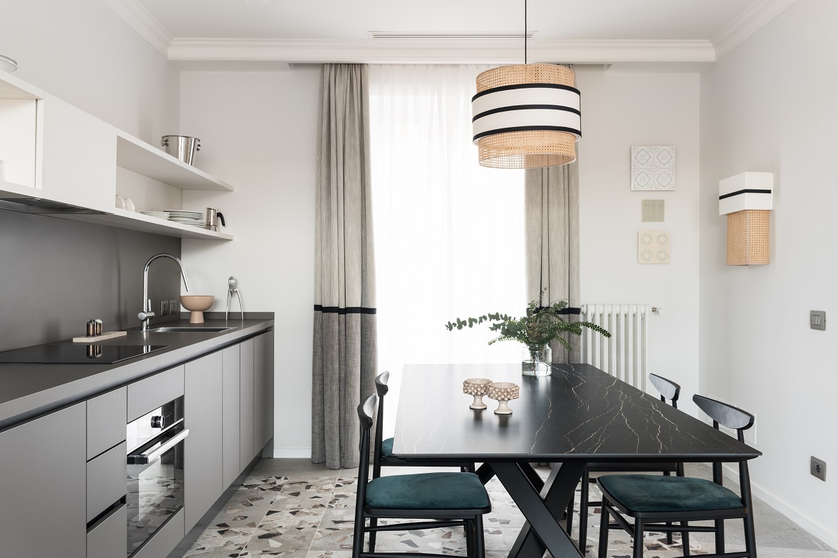 grey and neutral colour scheme in the kitchen with black central table and terrazzo floor in colosseo apartment from THDP