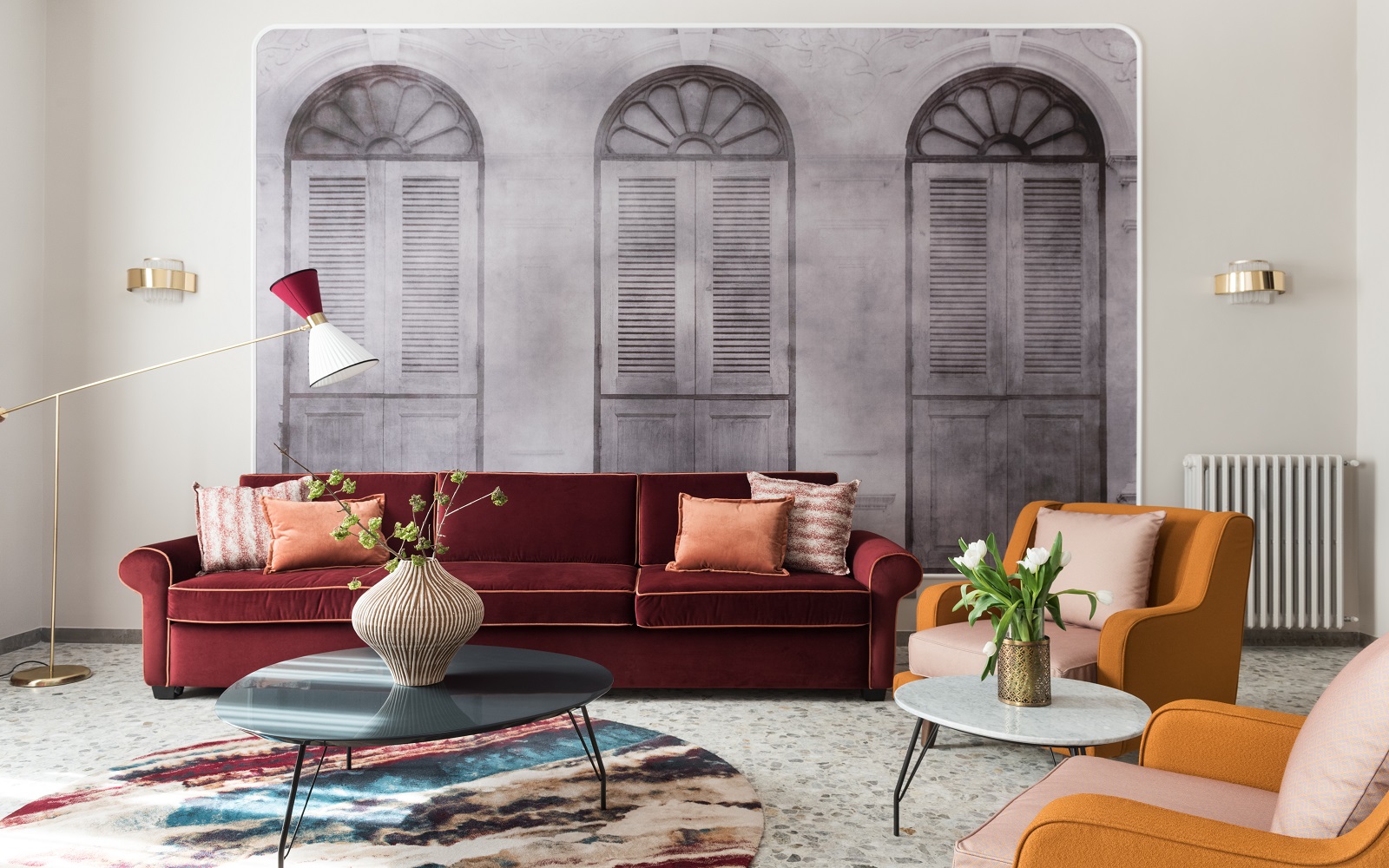 rust and mustard couch and chairs in front of faded mural of roman facade in THDP apartment Piazza Navona