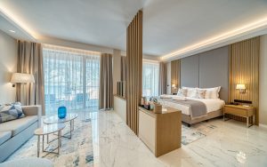 hotel guestroom with marble floors and wooden room divider between seating and bed in Hyatt Regency Kotor Bay Resort
