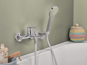 ONovo tap and shower from Villeroy & Boch against olive green wall with basket and soap on the bath