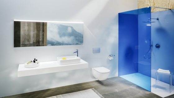 bathroom design with blue glass shower enclosure and white shower tray from Laufen next to double sink on a vanity below a mirror