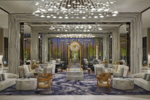 hotel lobby in shades of cream and gold with sparkling feature lights and columns drawing you in
