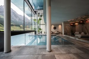 indoor pool with floor to ceiling windows giving a view out to the mountains