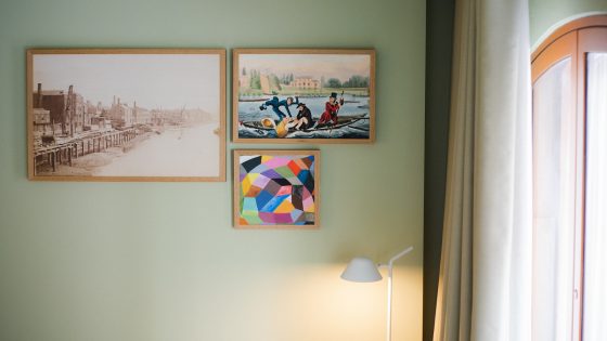 sage green wall in a hotel guestroom with a curated gallery art wall