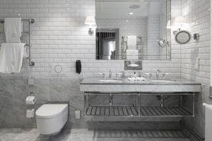 white metro tiles on a bathroom wall adjacent to grey and white marble surfaces in the guestroom at Grand Hotel Stockholm
