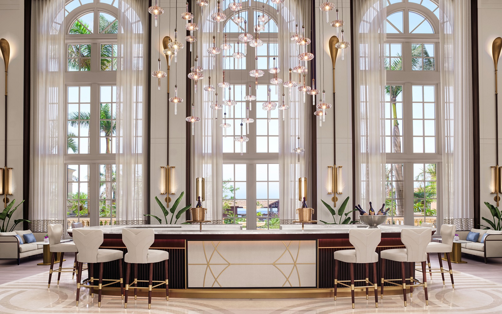 three floor to ceiling arched windows behind the white and wood lobby bar in the Ritz Carlton Naples