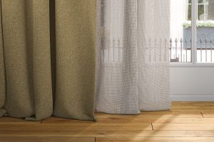 detail of sheer and blackout curtain hemline on wooden floor