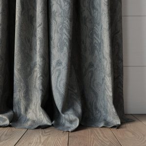 grey marble effect fabric curtain falling onto wooden floor