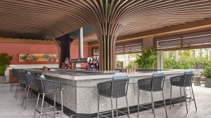 central bar with seating overlooking the gardens and a statement wooden ribbed ceiling