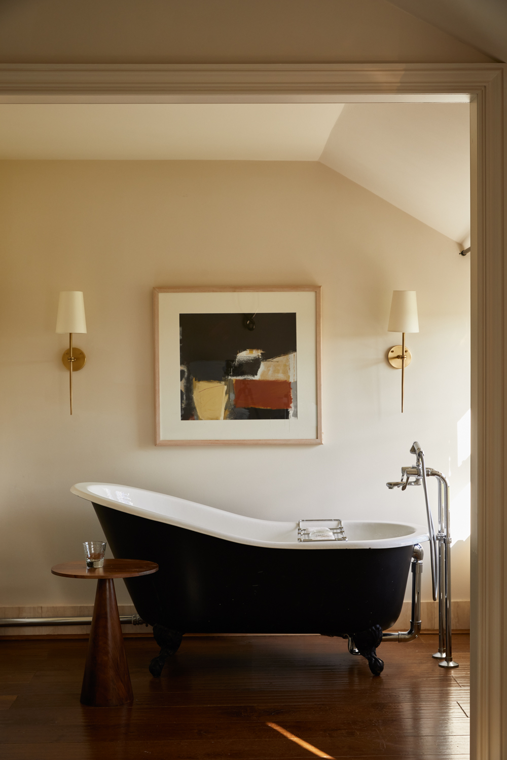 The Grove in Hertfordshire bathroom - black bath with 70s art on wall