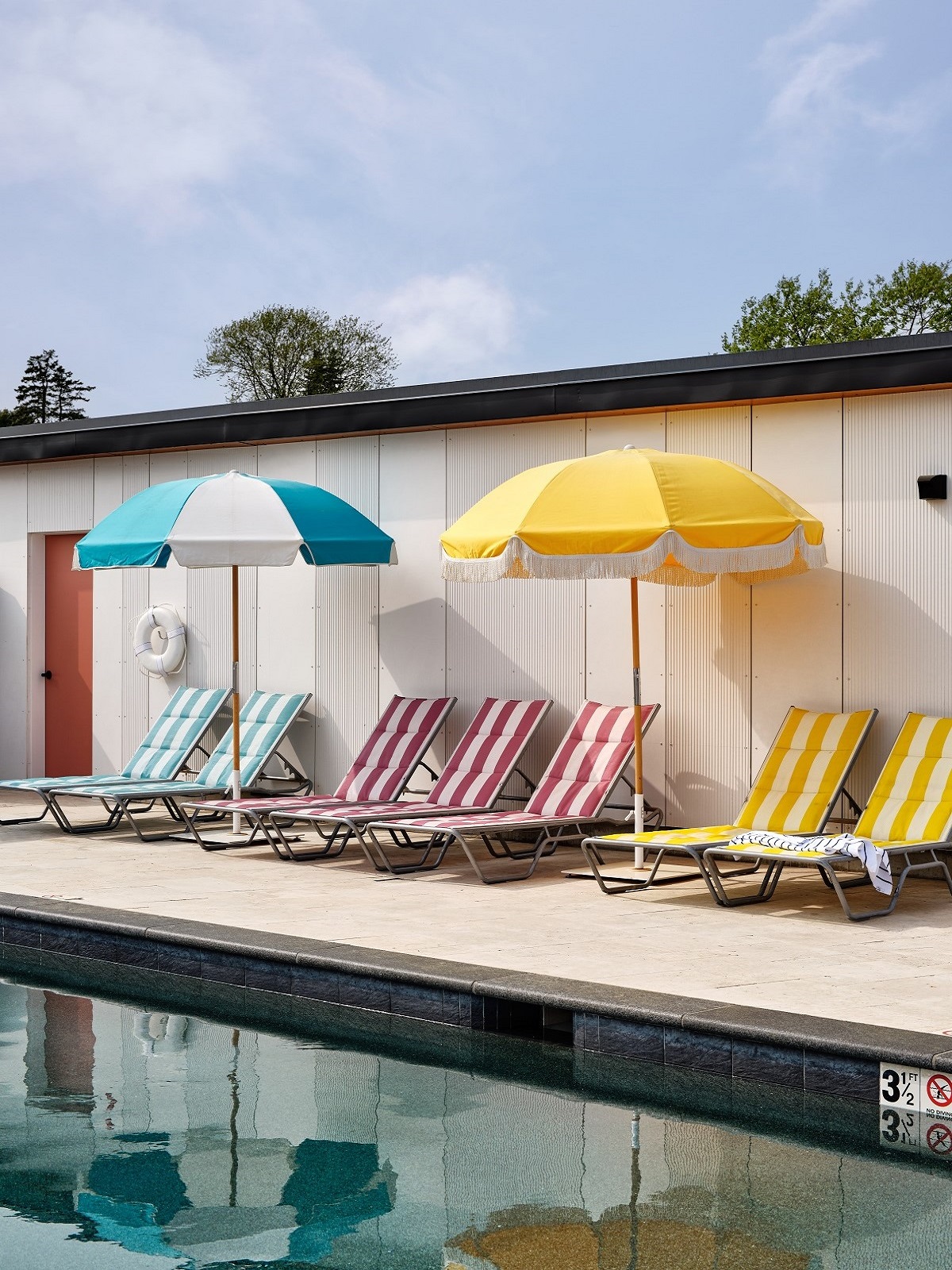 colourful striped loungers and umbrellas in a vintage style around the swimming pool