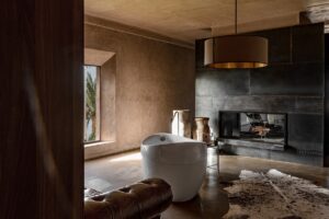 central freestanding bath in the ensuite for mastersuite at Villa d with fireplace and warm terracotta surfaces