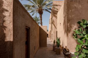 square architectural lines of clay building with palm tree in Marrakech Morocco