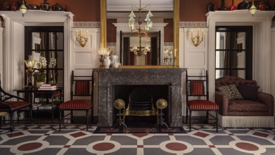 grey and brown victorian tiled floor in front of period fireplace flanked by chairs in One Sloane
