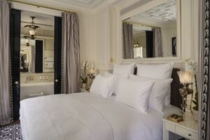 cream and white bedroom design with period details in guestroom leading on to ensuite bathroom