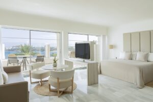 white and grey marble floors, white walls, white and beige furniture and soft furniture in a guest suite with ocean views