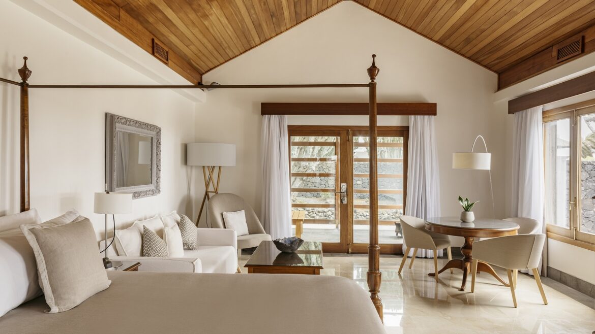 wooden ceilings and cream floors and walls in a guestroom with wooden bed detail and white and cream fabrics in Paradisus Salinus