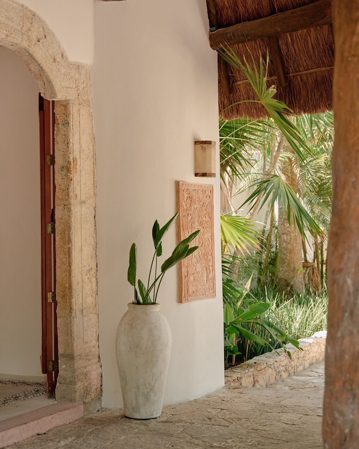natural surfaces and shapes with wood and clay details in passageway leading to tropical gardens