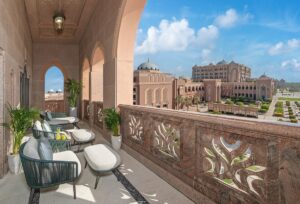 cream furniture and stone finishes on the balcony outside guestroom at Mandarin Oriental Emirates with view over hotel gardens