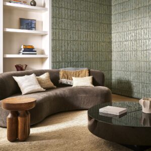 brown curved retro couch in front of shelving recessed in wall covered in Arte Metal X Patina