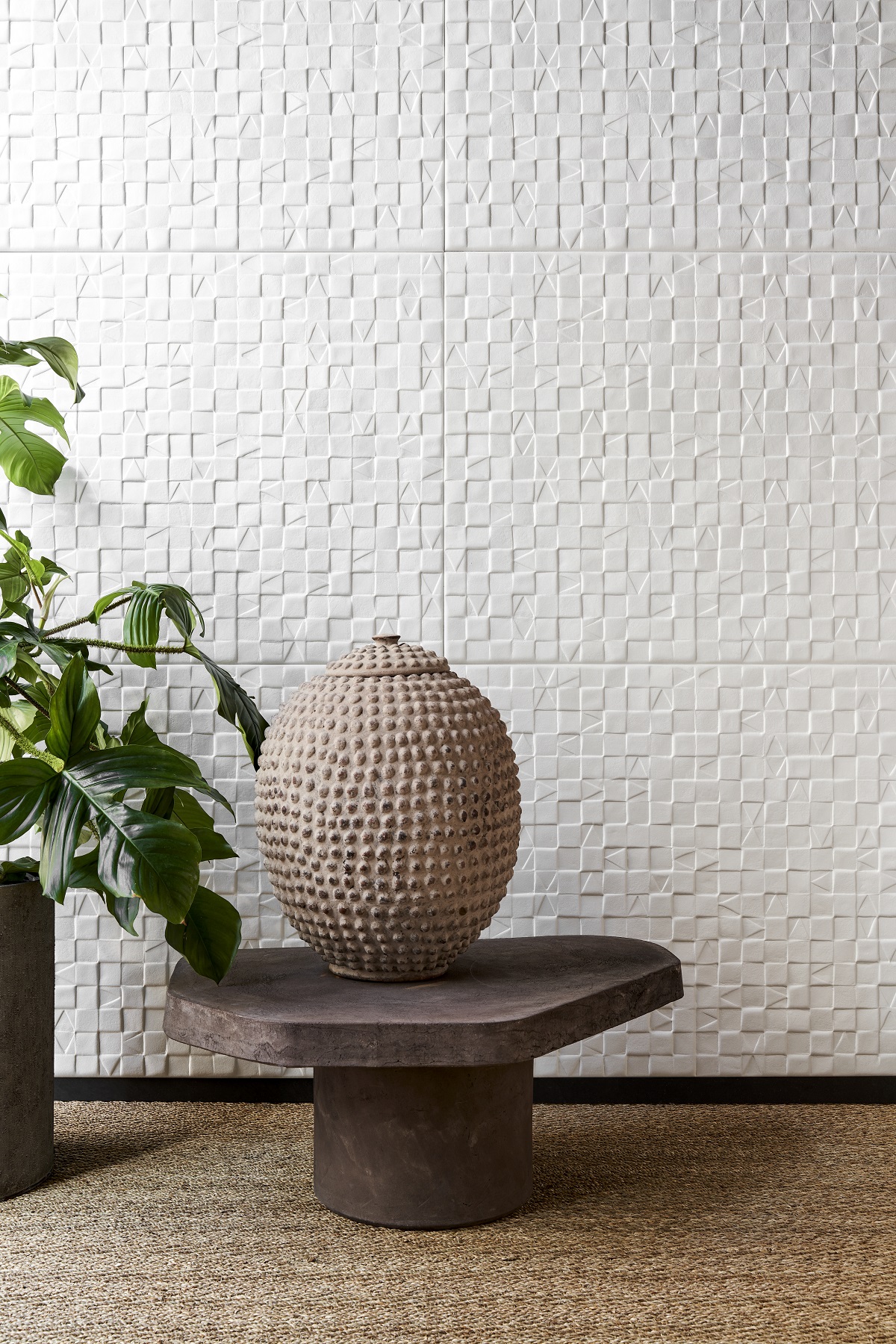 wooden table and clay pot in front of white adobe textured wallcovering