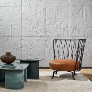 white relief wallcovering behind metal chair