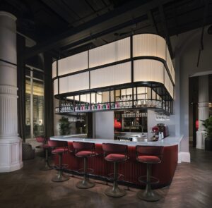 red velvet seating around the bar with industrial inspired lighting feature above by Northern Lights