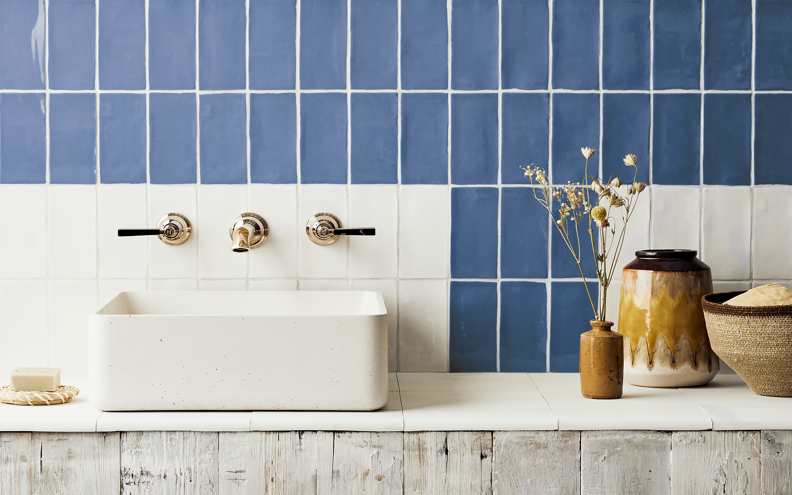 navy blue glazed tiles in contrasting pattern to cream glazed tiles from Hyperion tiles behind a concrete basin on a wooden surface