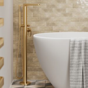 brass tap pillar next to white bath in front of dark cream brick wall tiles