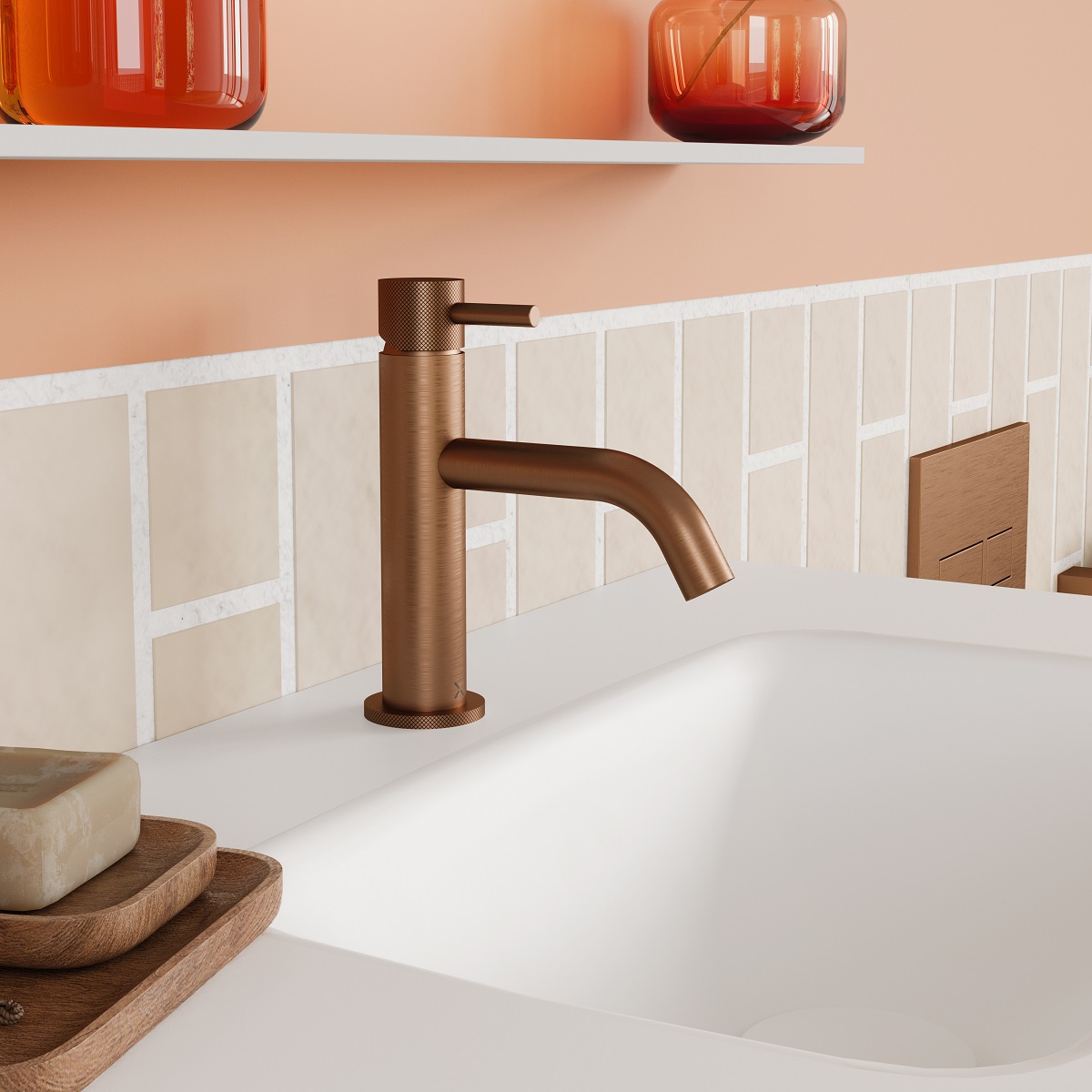 bathroom sink with brushed bronze tap, peach walls and orange glass container on shelf