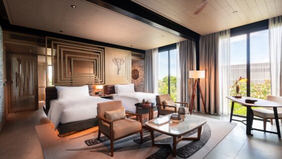 double bed in centre of room with floor to ceiling windows looking out over Sri Lankan landscape at Hilton Yala Resort