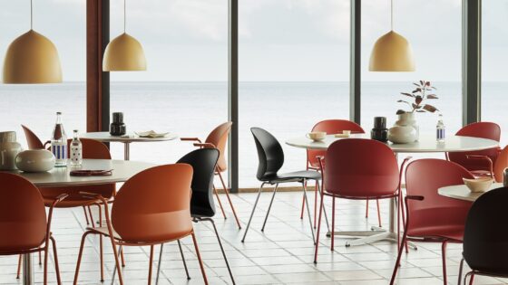 dark orange, red and black recycled chairs from ?Fritz Hansen in a restaurant setting with sea view