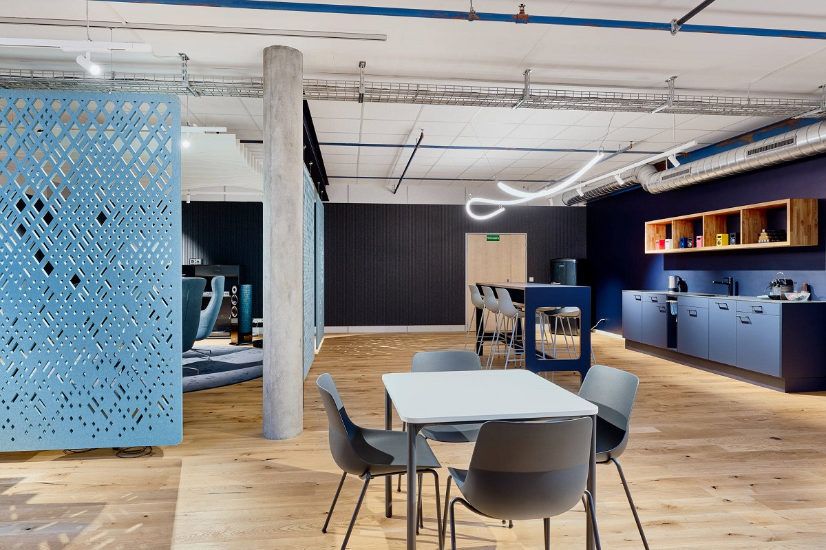 An open-plan office public area with light blue acoustic panel