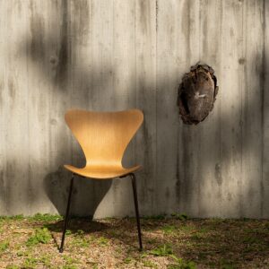 wooden chair in front of wood panelled outdoor wall