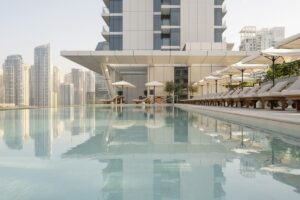view across the water of the swimming pool at Vida Dubai Marina with views of the city