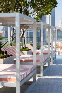 striped cabanas line the rooftop pool at Mondrian Singapore