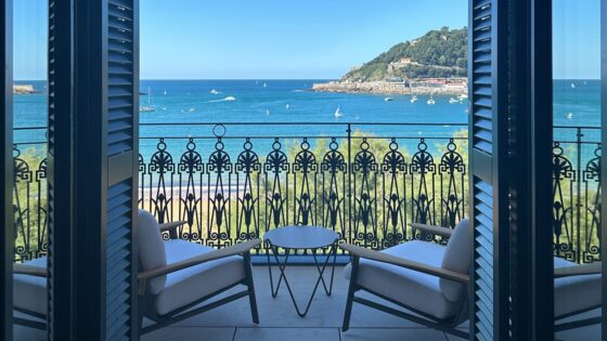 two chairs and a table on a balcony of Nobu San Sebastian in front of ornate balustrade with sea view
