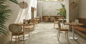 stone coloured tiled floor in River tile collection from CTD tiles in a restaurant with plants and wicker and wood furniture