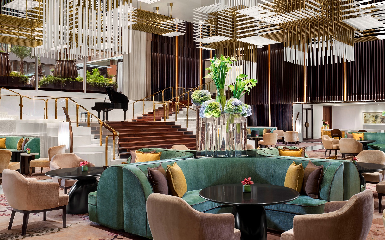 lobby of St Regis Jakarta with statement ceiling lights and plush pink and teal blue seating